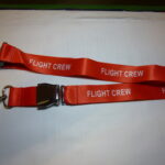 Porta Badge Flight Crew di colore rosso da collo stampato, con chiusura cintura sicurezza aereo.